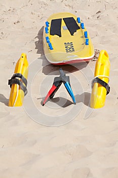 Lifesaving raft, floation devices and swimming fins on beach