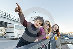 Lifestyle of adolescents, boy and two teen girls are walking in the city. Laughing, talking children eating street food, having