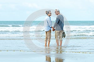Lifestyle asian senior couple happy walking and relax on the beach.