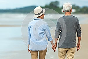 Lifestyle asian senior couple happy walking and relax on the beach.  Tourism elderly family travel leisure