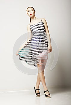 Lifestyle. Attractive Slim Female wearing Sleeveless Tabby Dress. Sensuality