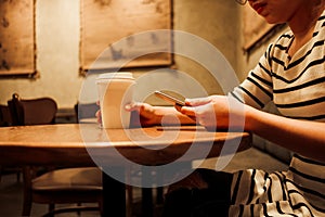 Lifestyle background woman holding coffee glass and using mobile