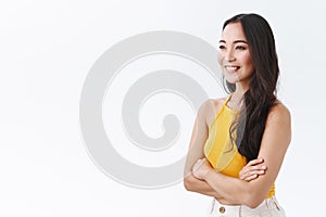 Lifestyle, beauty and emotions concept. Cheerful, self-assured young east-asian woman in yellow top, standing half