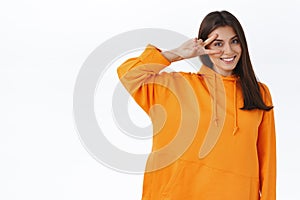 Lifestyle, beauty and women concept. Portrait of adorable brunette caucasian girl in orange hoodie, sending good vibes