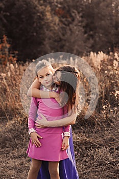 Lifestyle capture of happy mother and preteen daughter having fun outdoor. Loving family spending time together on the walk.