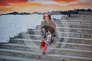 lifestyle cheerful girl in the city at sunset in camouflage clothing female portrait, urbanisation concept
