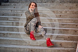 lifestyle cheerful girl in the city at sunset in camouflage clothing female portrait, urbanisation concept