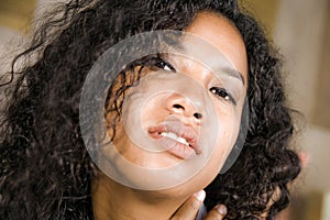 Lifestyle close up head portrait of young beautiful and mixed ethnicity latin and African American woman with gorgeous curly