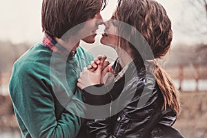 Lifestyle close up outdoor portrait of young loving couple kissing