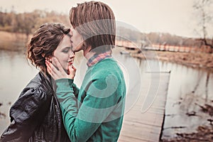 Lifestyle close up outdoor portrait of young loving couple kissing