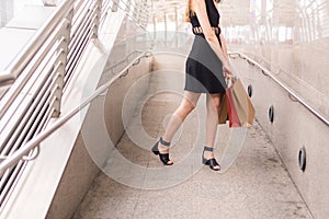 Lifestyle concept,Confident girl in blackdress smling and holding shopping bags in city photo