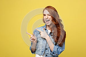 Lifestyle Concept: Happy excited cuacaisan tourist girl pointing finger on copy space on golden yellow