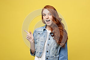 Lifestyle Concept: Happy excited cuacaisan tourist girl pointing finger on copy space isolated on golden yellow