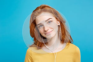Lifestyle concept - Portrait of cheerful happy ginger red hair girl enjoy listening to music with headphones joyful