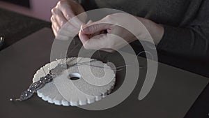 Lifestyle concept, reinvent your life and your job: close-up detail in low angle view of woman hands making macrame knotted