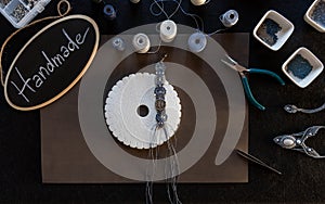 Lifestyle concept, reinvent your life and your job: flat lay top view of macrame jewels with colored spools of thread, a bracelet