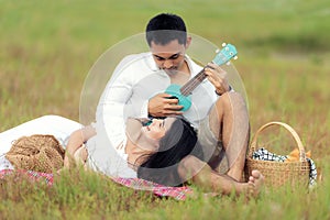 Lifestyle couple happy honeymoon in sunny time. Asian young couple sitting picnic and relax