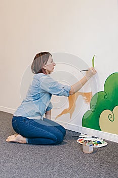 Lifestyle creative hobby and freelance artistic work side job concept. Caucasian woman artist hand painting murals on walls