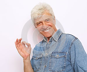 Lifestyle, emotion  and people concept: Handsome mature man in casual wear is showing Ok sign