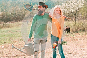 Lifestyle and family life. Eco living. A farmer and his wife standing in their field. Two people gardening in the