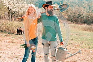 Lifestyle and family life. Eco living. A farmer and his wife standing in their field. Two people gardening in the