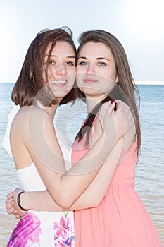 Lifestyle fashion portrait of two pretty fresh young lesbian best friends girls having vacation on tropical island beach