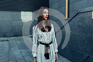 Lifestyle fashion portrait of young stylish hipster woman with sunglasses walking on the street, wearing cute trendy outfit enjoy