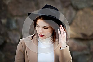 Lifestyle fashion portrait of young stylish hipster woman walking on the street.