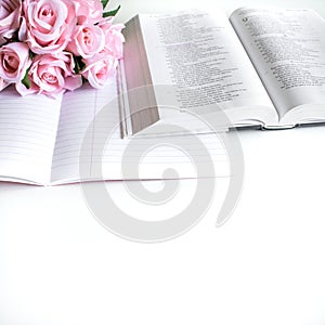 Flat lay with different accessories; flower bouquet, pink roses, open book, Bible