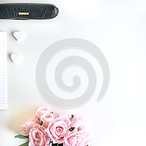 Flat lay with different accessories; flower bouquet, pink roses, open book, Bible