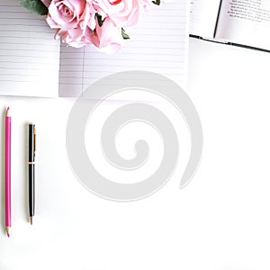 Flat lay with different accessories; flower bouquet, pink roses, open book, Bible