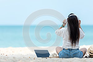 Lifestyle freelance woman listen music after using laptop working and relax on the beach