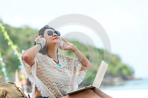 Lifestyle freelance woman listen music after using laptop working and relax on the beach.
