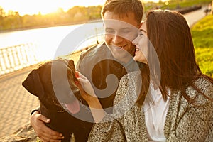 Lifestyle, happy family resting at picnic in the park with a dog