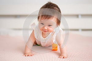 lifestyle home portrait of 9 months old mixed ethnicity Asian Caucasian baby girl playing happy and carefree on bed crawling and