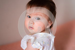 lifestyle home portrait of adorable and beautiful Asian Caucasian mixed baby girl looking to the camera with adorable face