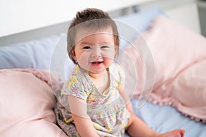 lifestyle home portrait of happy and adorable 9 months old mixed ethnicity Asian Caucasian baby girl playing cheerful and carefree