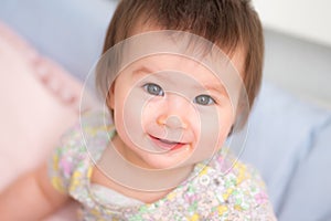 lifestyle home portrait of happy and adorable 9 months old mixed ethnicity Asian Caucasian baby girl playing cheerful and carefree