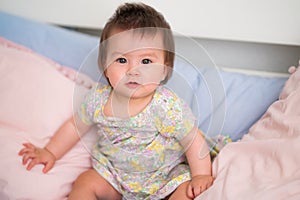 lifestyle home portrait of happy and adorable 9 months old mixed ethnicity Asian Caucasian baby girl playing cheerful and carefree