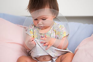 lifestyle home portrait of happy and adorable 9 months old mixed ethnicity Asian Caucasian baby girl playing cheerful and carefree