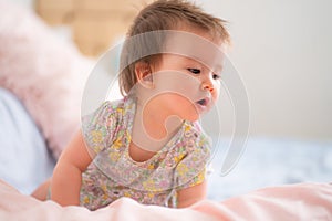 lifestyle home portrait of happy and adorable 9 months old mixed ethnicity Asian Caucasian baby girl playing cheerful and carefree