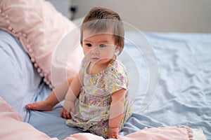 lifestyle home portrait of happy and adorable 9 months old mixed ethnicity Asian Caucasian baby girl playing cheerful and carefree