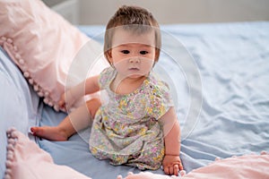 lifestyle home portrait of happy and adorable 9 months old mixed ethnicity Asian Caucasian baby girl playing cheerful and carefree