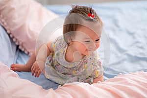 lifestyle home portrait of happy and adorable 9 months old mixed ethnicity Asian Caucasian baby girl playing cheerful and carefree