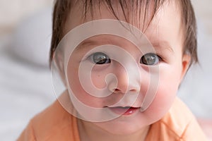 lifestyle home portrait of happy and beautiful 8 months old baby girl mixed race Asian Caucasian playing cheerful on bed exploring