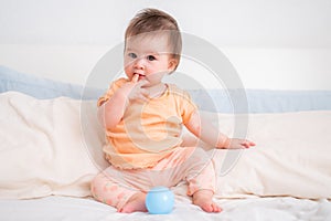 lifestyle home portrait of happy and beautiful 8 months old baby girl mixed race Asian Caucasian playing cheerful on bed exploring