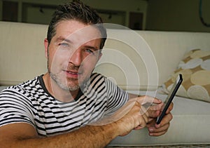 Lifestyle home portrait of young happy and attractive 30s man using internet dating app or messaging social media on mobile phone