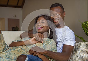 Lifestyle home portrait of young happy and successful romantic African American couple in love relaxed sitting comfortable