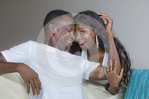 Lifestyle home portrait of young happy and successful romantic afro American couple in love relaxed sitting comfortable together