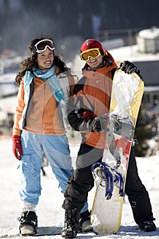 A lifestyle image of two young adult snowboarders